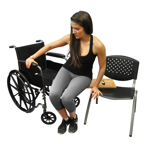 Woman sitting on a chair next to a wheelchair on a white background