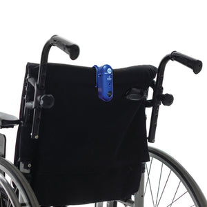 Wheelchair with a blue device attached to the backrest on a white background for seniors
