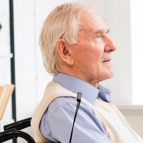 Senior man in a wheelchair with a neck brace, looking to the side.